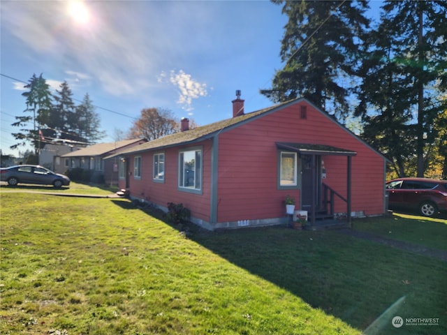 view of side of property with a lawn