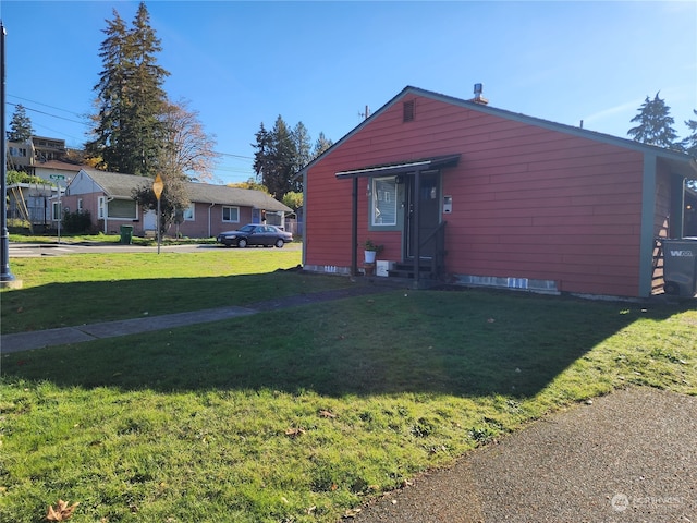 view of side of home with a yard