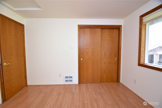 unfurnished bedroom with a closet and light hardwood / wood-style flooring