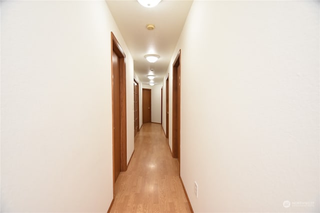 corridor with light hardwood / wood-style floors