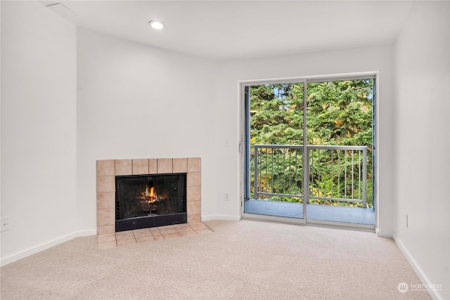 unfurnished living room featuring a fireplace and light colored carpet