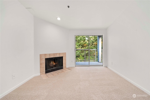 unfurnished living room featuring light carpet and a tiled fireplace