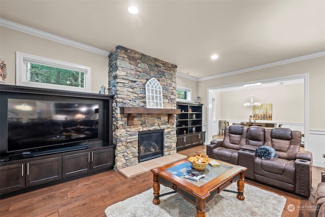 living room featuring a stone fireplace, wood-type flooring, and ornamental molding