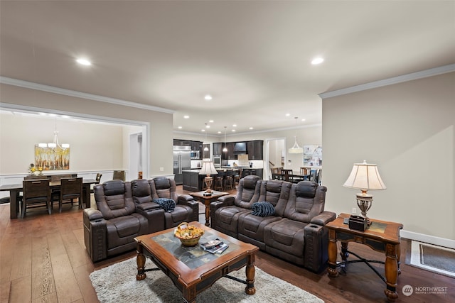 living room with hardwood / wood-style flooring, a notable chandelier, and ornamental molding