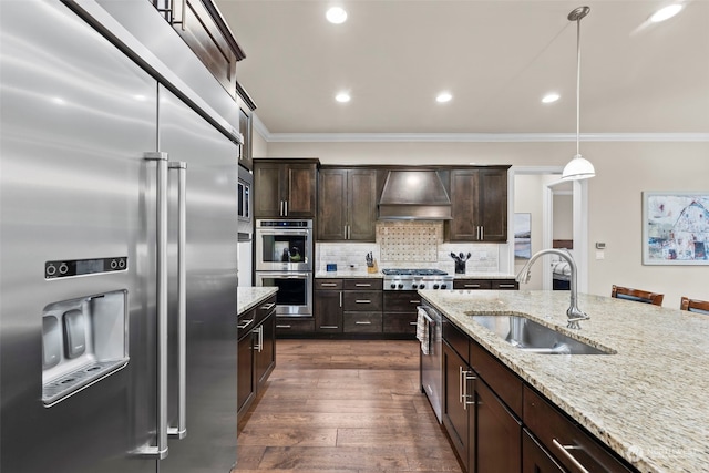 kitchen with dark hardwood / wood-style flooring, premium range hood, stainless steel appliances, sink, and pendant lighting