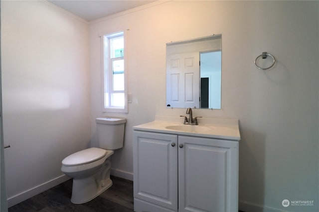 bathroom with hardwood / wood-style floors, vanity, toilet, and ornamental molding