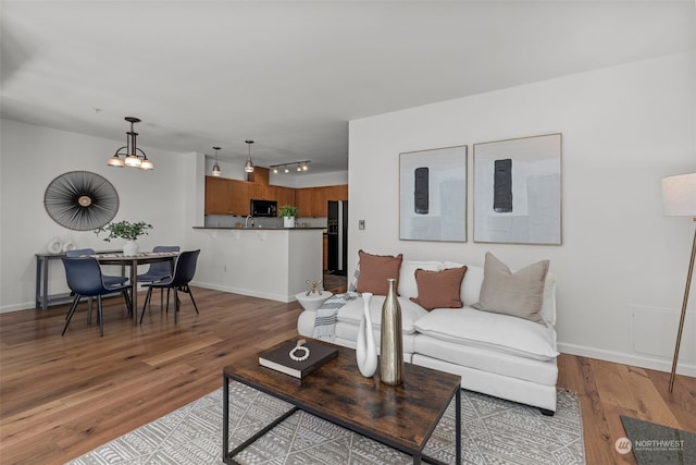 living room featuring a notable chandelier and light hardwood / wood-style flooring