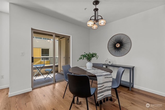 dining area with wood-type flooring and a notable chandelier