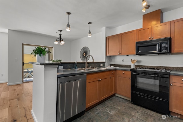 kitchen featuring black appliances, pendant lighting, sink, dark wood-type flooring, and kitchen peninsula