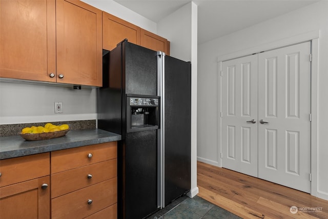 kitchen featuring black refrigerator with ice dispenser and dark hardwood / wood-style flooring