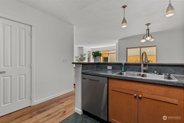 kitchen with dark hardwood / wood-style flooring, hanging light fixtures, stainless steel dishwasher, and sink