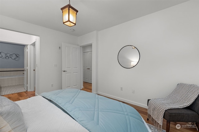 bedroom with ensuite bathroom and wood-type flooring