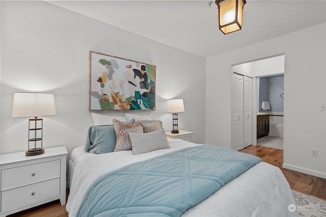 bedroom featuring a closet, hardwood / wood-style floors, and ensuite bathroom