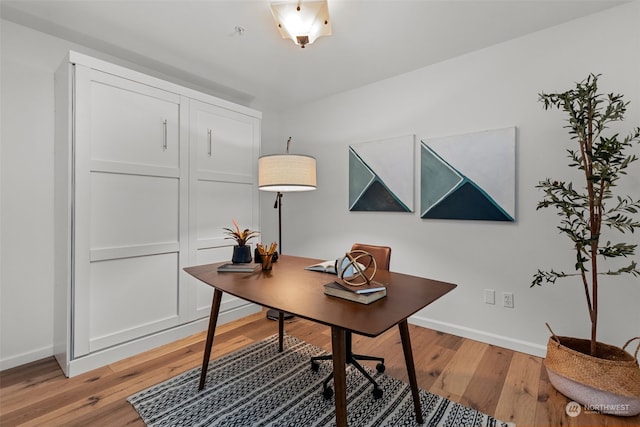 home office with light hardwood / wood-style flooring