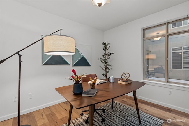 home office featuring hardwood / wood-style flooring and a healthy amount of sunlight