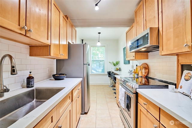 kitchen with stainless steel appliances, backsplash, light tile patterned floors, pendant lighting, and sink