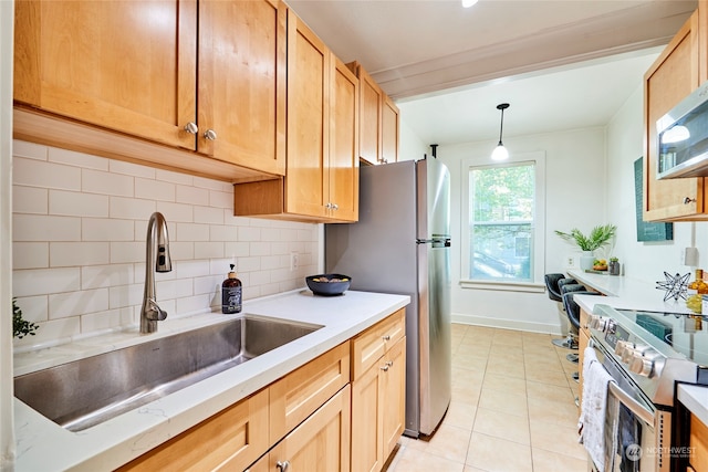 kitchen featuring stainless steel appliances, sink, light tile patterned floors, decorative light fixtures, and backsplash