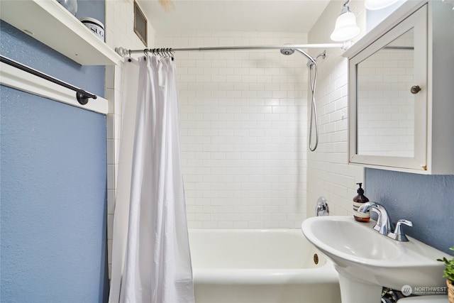 bathroom with shower / bath combo and sink