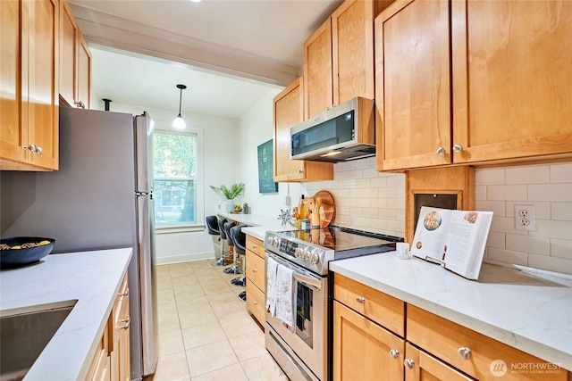 905 NE 43rd St Unit 108, Seattle, WA 98105 - kitchen with stainless steel appliances, tasteful backsplash, light tile patterned floors, and a sink