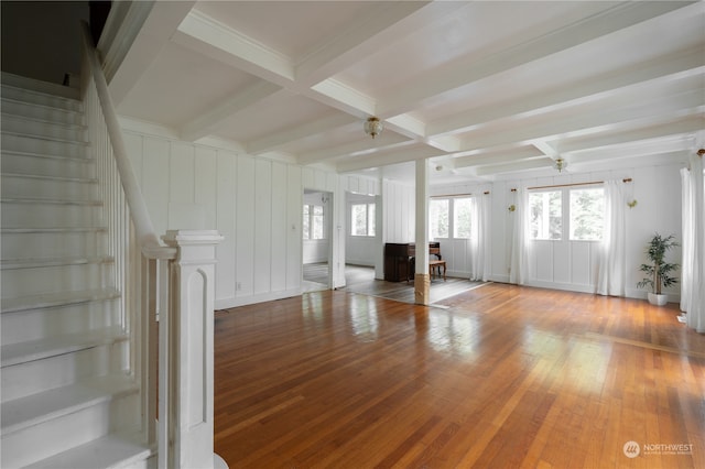 unfurnished living room with wood-type flooring, ceiling fan, and beam ceiling