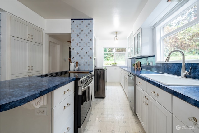 kitchen with a healthy amount of sunlight, stainless steel appliances, sink, and white cabinets