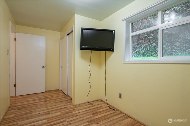 unfurnished bedroom with a closet and light hardwood / wood-style flooring