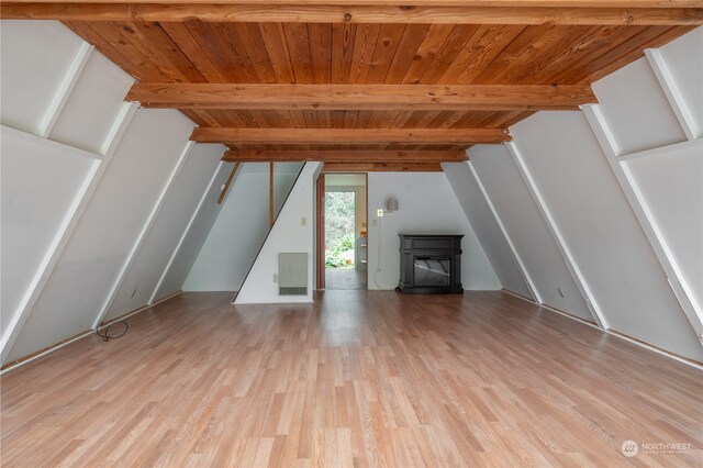 unfurnished living room with light wood-type flooring, beam ceiling, and wooden ceiling