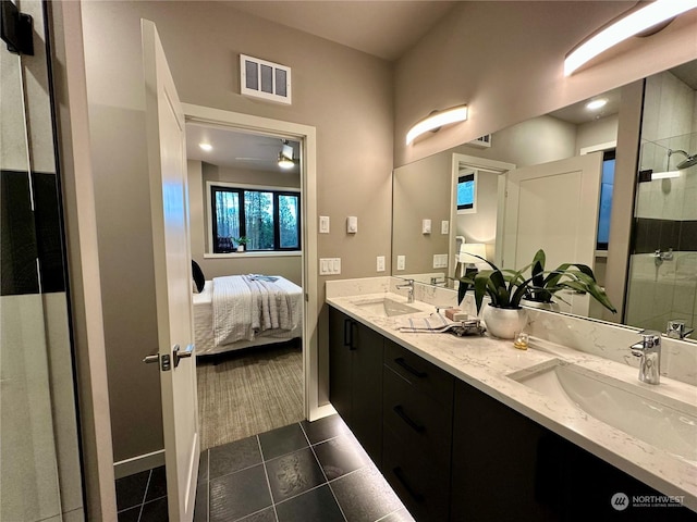 bathroom with a shower with door, vanity, and tile patterned floors