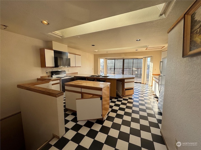 kitchen featuring sink, a textured ceiling, kitchen peninsula, range with electric cooktop, and white cabinets