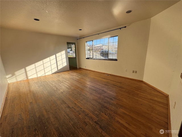 spare room with hardwood / wood-style flooring and a textured ceiling