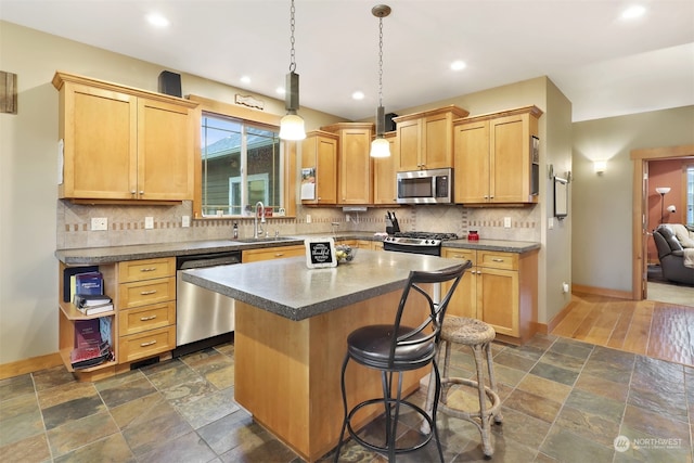 kitchen featuring light brown cabinetry, sink, a center island, and appliances with stainless steel finishes