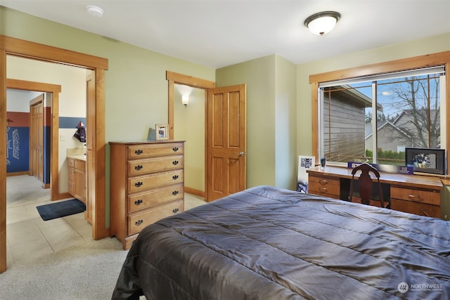 carpeted bedroom featuring ensuite bathroom and built in desk