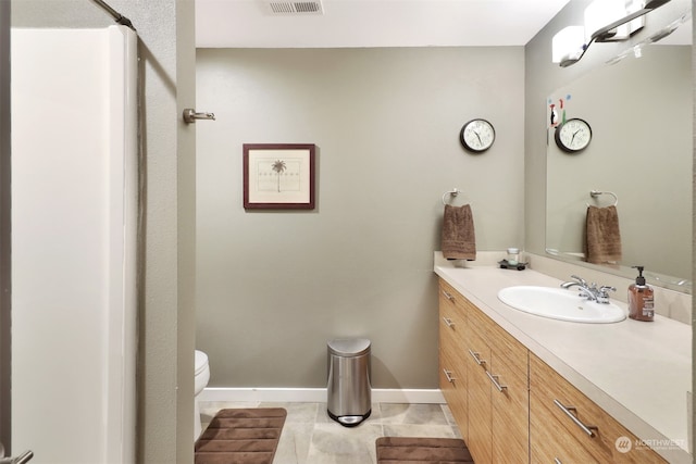 bathroom with tile patterned flooring, vanity, and toilet