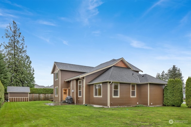 back of property with a storage unit and a lawn