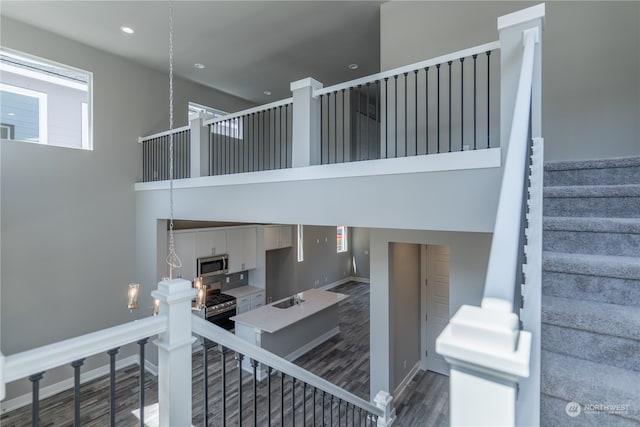 stairs featuring hardwood / wood-style floors and sink