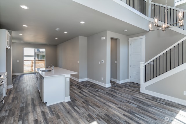 kitchen with pendant lighting, white cabinetry, dark wood-type flooring, and an island with sink