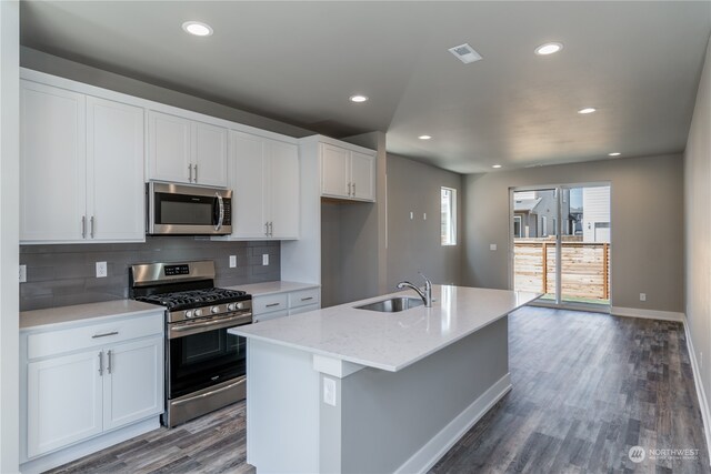 kitchen with a kitchen island with sink, stainless steel appliances, sink, and white cabinets