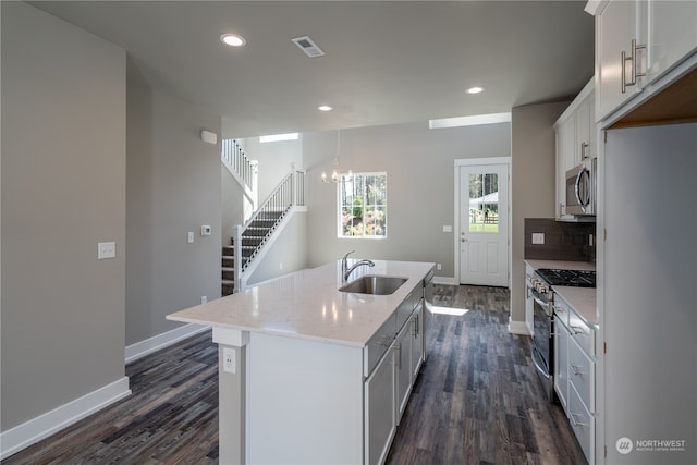 kitchen featuring stainless steel appliances, white cabinetry, sink, an island with sink, and dark hardwood / wood-style flooring