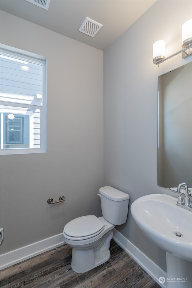 bathroom with toilet, sink, and wood-type flooring