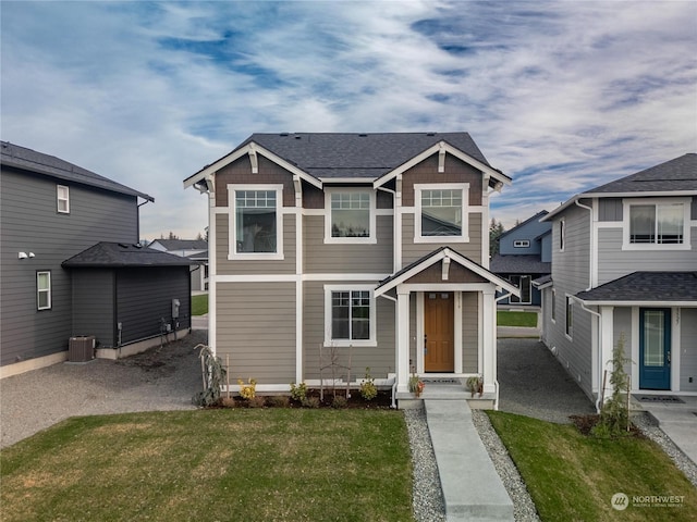 view of front of home featuring cooling unit and a front yard