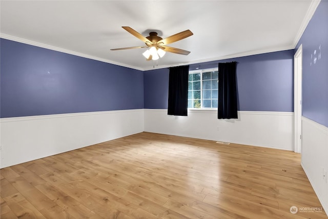 22222 Bluewater Dr SE, Yelm, WA 98597 - unfurnished room with a ceiling fan, ornamental molding, light wood-style flooring, and a wainscoted wall