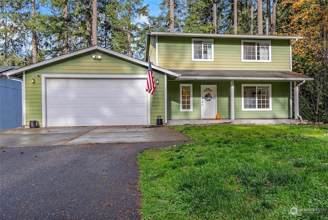 front facade with a garage, a front lawn, and covered porch