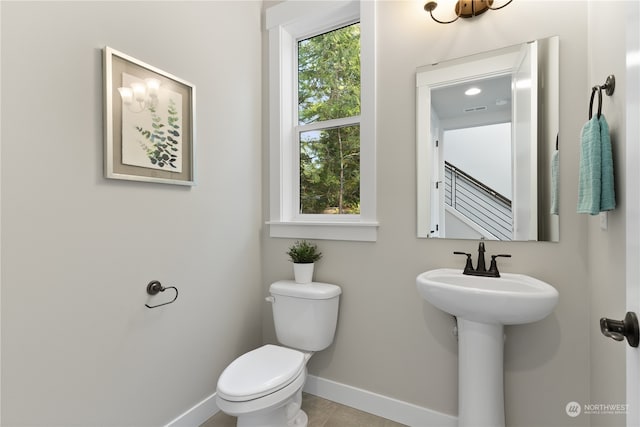 bathroom featuring tile patterned flooring, toilet, and sink