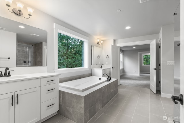 bathroom featuring tile patterned floors, vanity, and shower with separate bathtub