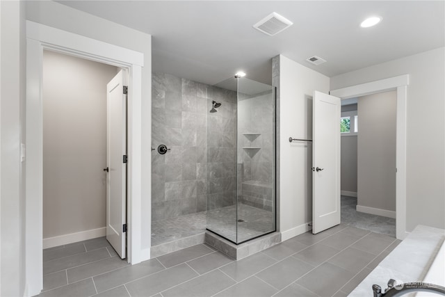 bathroom with tile patterned flooring and tiled shower