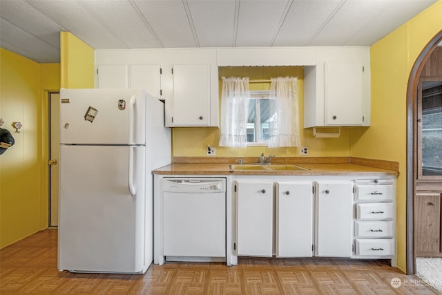 kitchen with white appliances, sink, and white cabinets