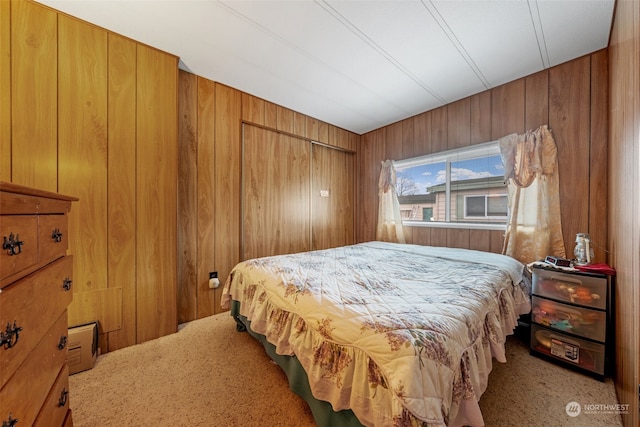 carpeted bedroom with wood walls