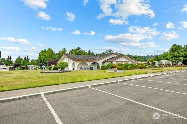 view of parking / parking lot with a yard