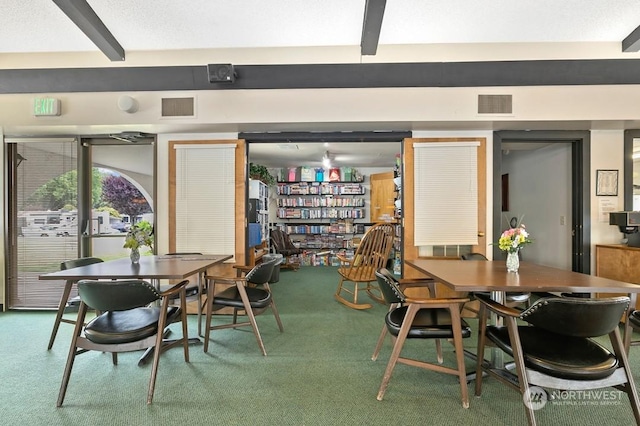 dining area featuring carpet floors and beamed ceiling