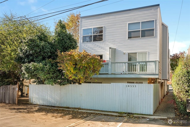 10335 Midvale Ave N, Seattle, WA 98133 - view of side of home with fence, a balcony, and uncovered parking